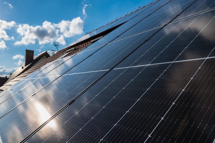 Photovoltaic panels on the roof with clouds reflections