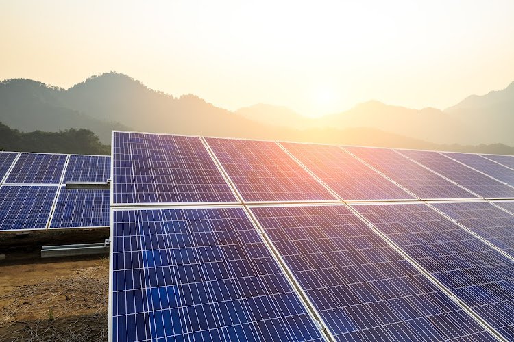 Solar panels and mountains landscape at sunrise